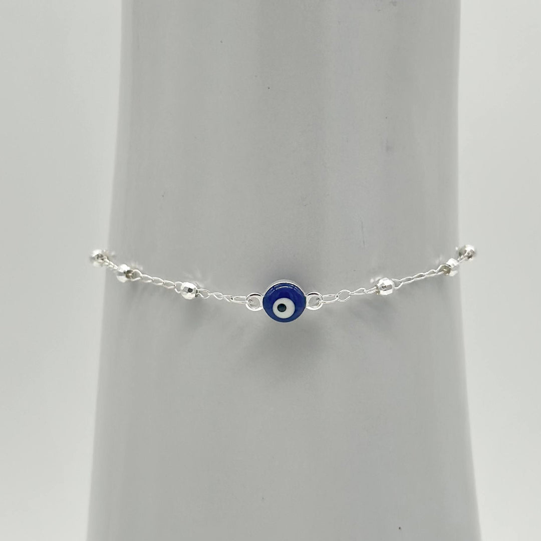 Pulsera de plata 925 con ojo turco azul central y bolitas facetadas, medida de 16 cm más 5 cm de extensión.