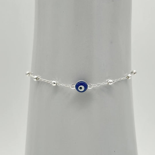 Pulsera de plata 925 con ojo turco azul central y bolitas facetadas, medida de 16 cm más 5 cm de extensión.