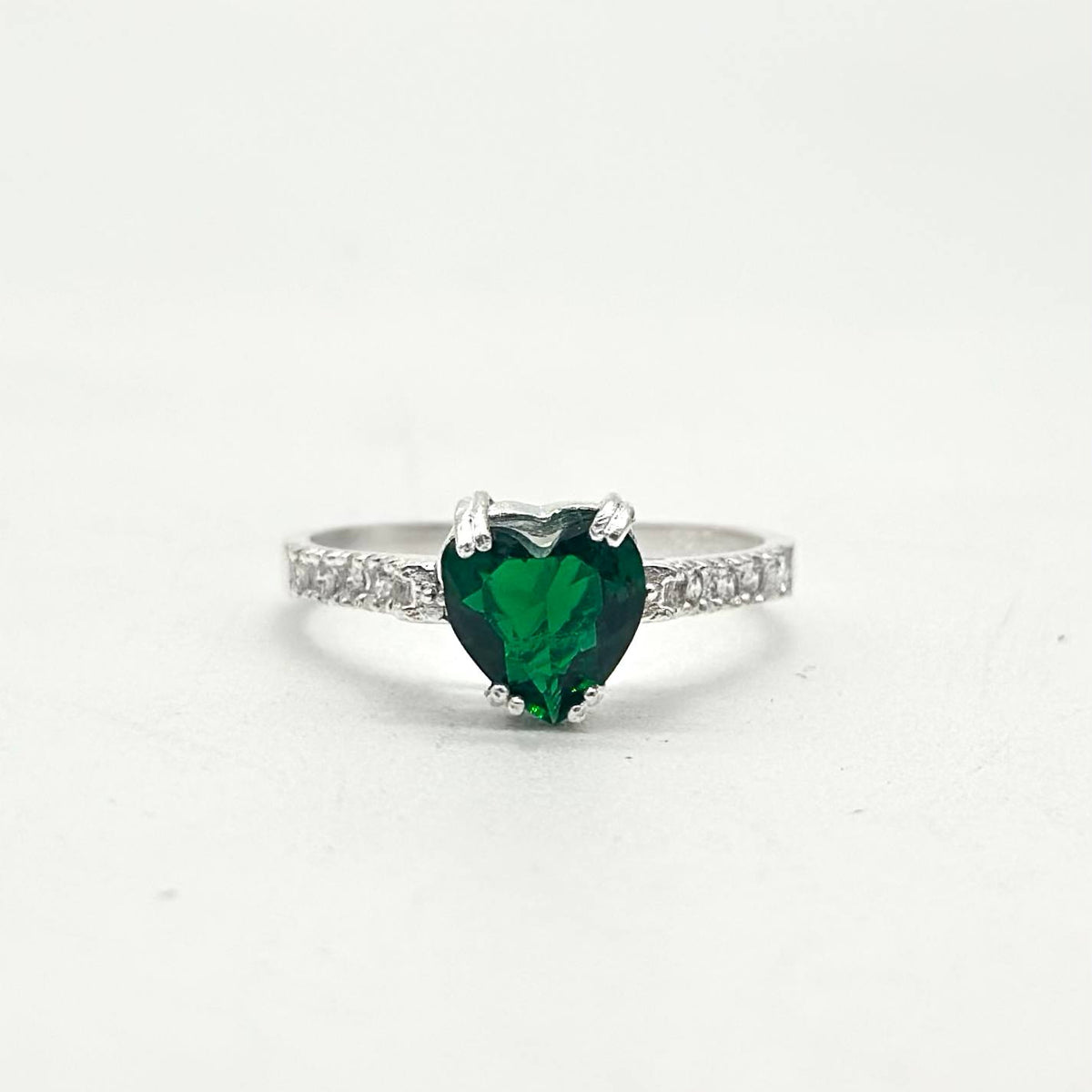 Anillo de plata 925 con zirconia verde en forma de corazón y zirconias brillantes incrustadas en los laterales.