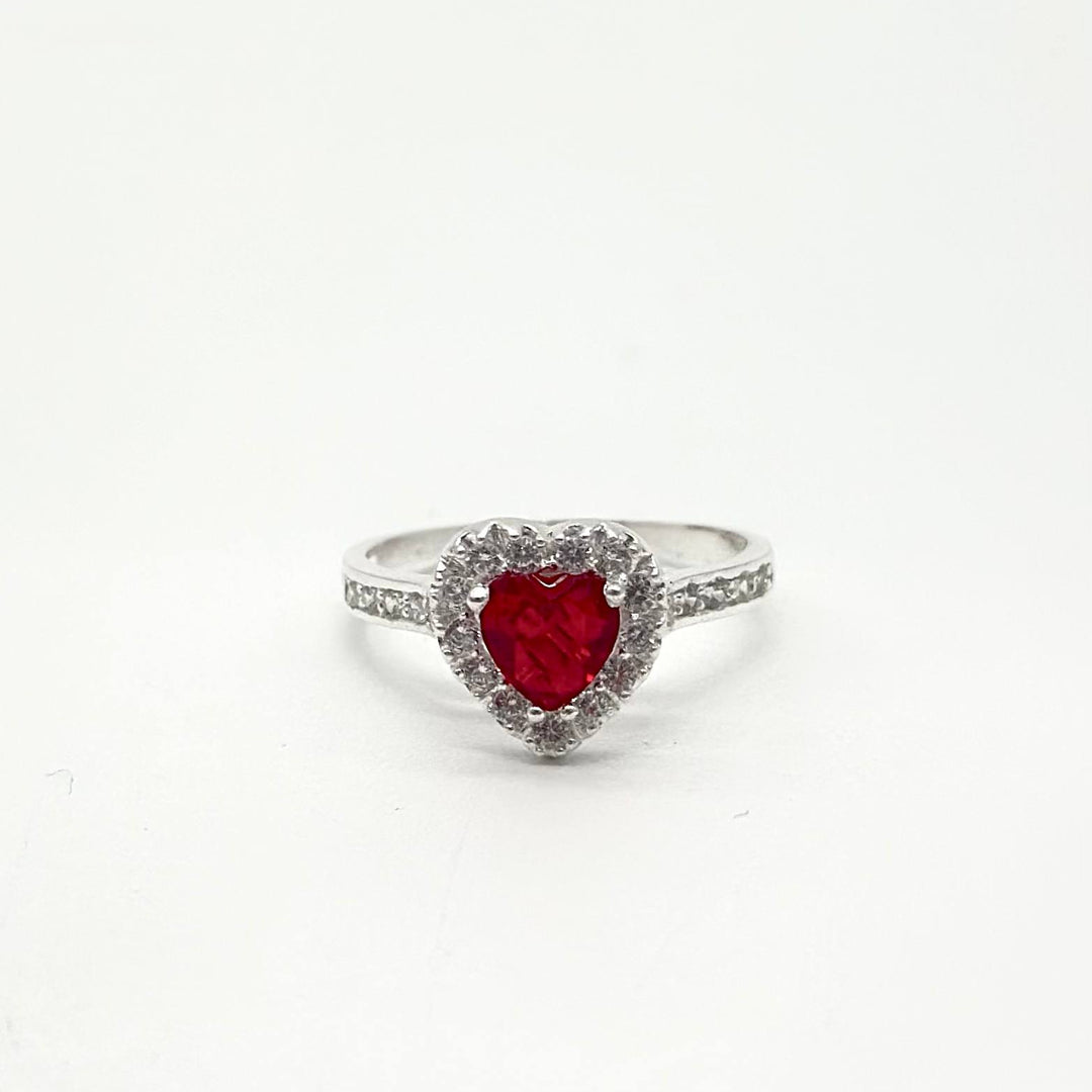 Anillo de plata 925 con piedra roja en forma de corazón rodeada de zirconias brillantes y acabado pulido.