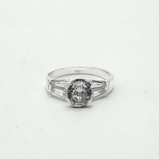 Anillo de plata 925 con zirconia central redonda y detalles laterales de corte baguette brillantes.