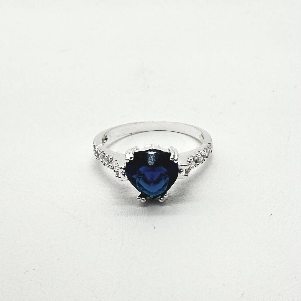 Anillo de plata 925 con piedra azul en forma de corazón y zirconias brillantes en los laterales.