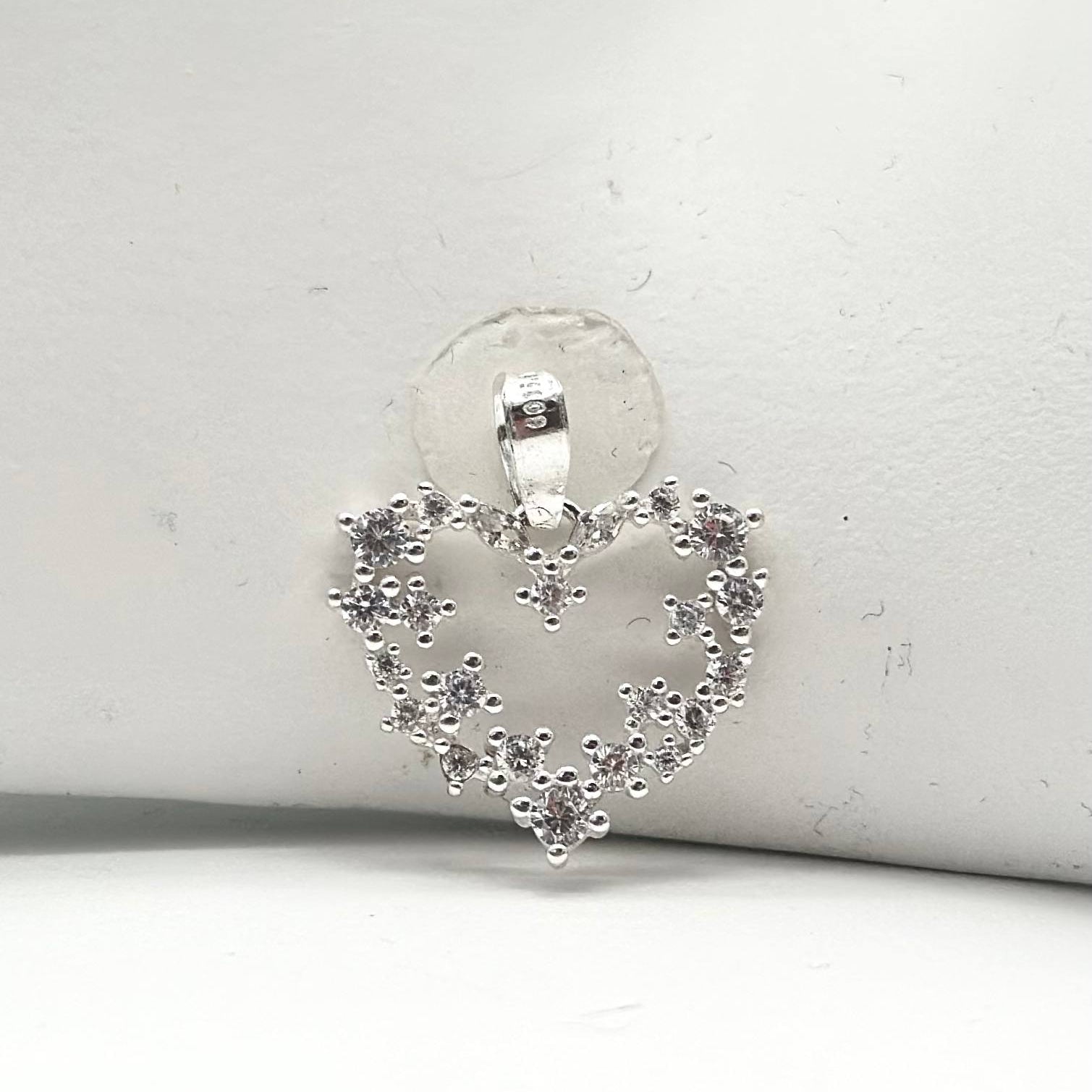 Dije de corazón abierto en plata 925 decorado con zirconias formando delicados detalles florales de 2 cm.
