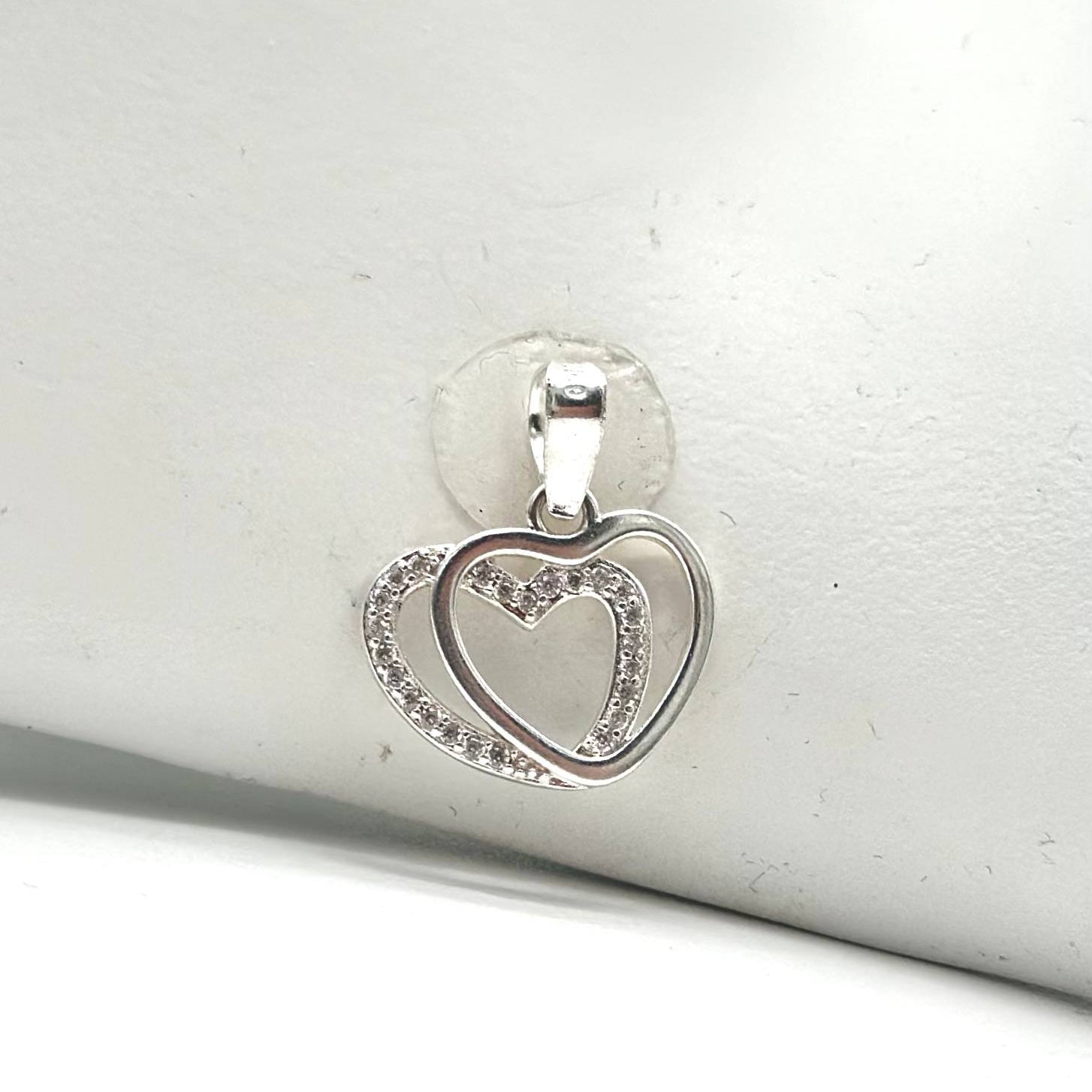 Dije de corazones entrelazados en plata 925 decorado con zirconias brillantes y acabado pulido.
